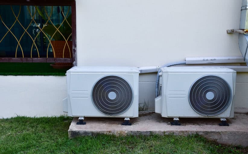 blanc deux unités de ventilateur de conditionnement installées sur le sol en ciment du bâtimen