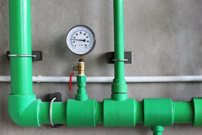 l'eau pression jauge avec soupape dans tuyau sur béton mur